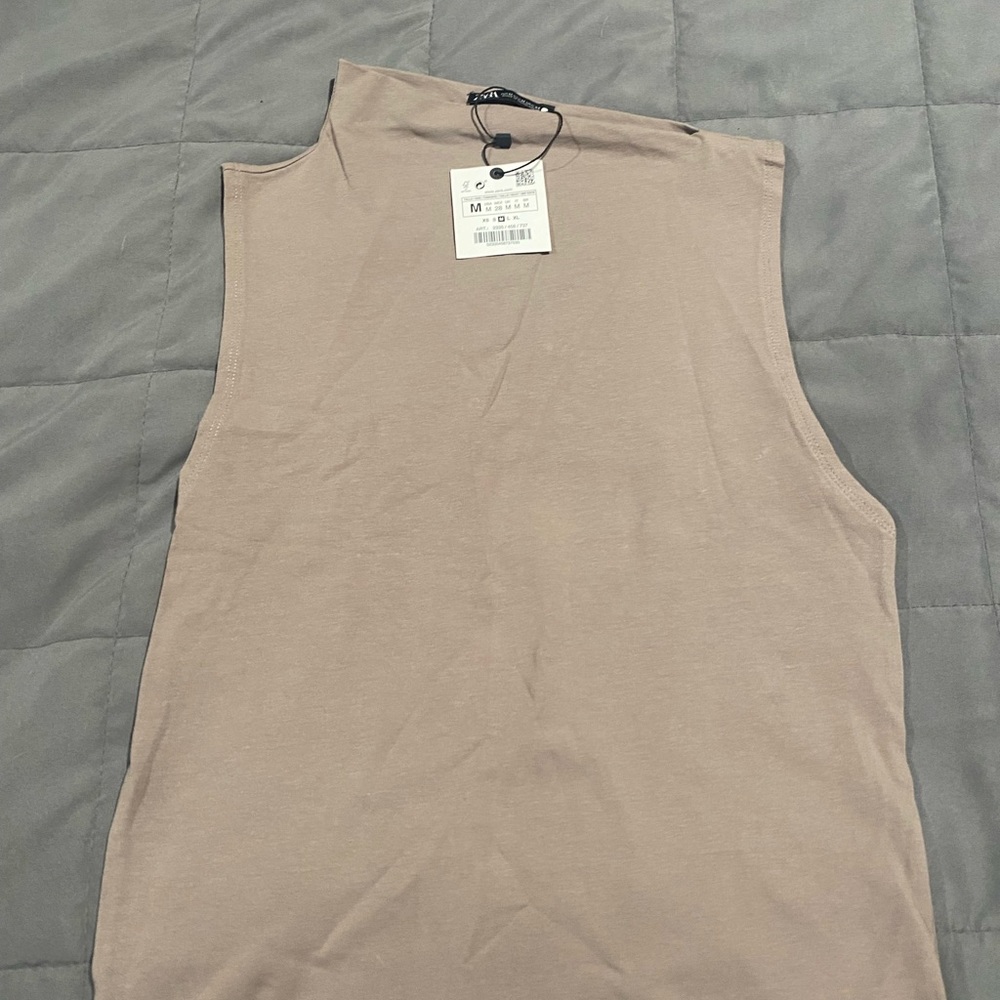 Tan sleeveless top with a sideway collar